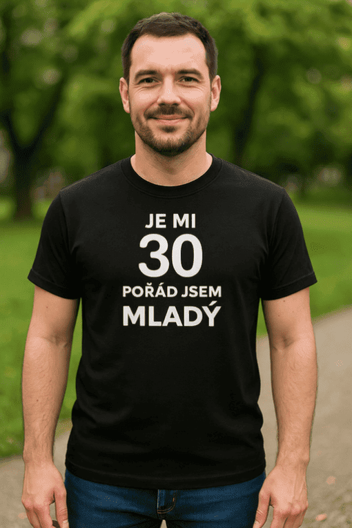 2. Muž v černém tričku s nápisem "Je mi 30, pořád jsem mladý" stojí v parku, oslavu narozenin.