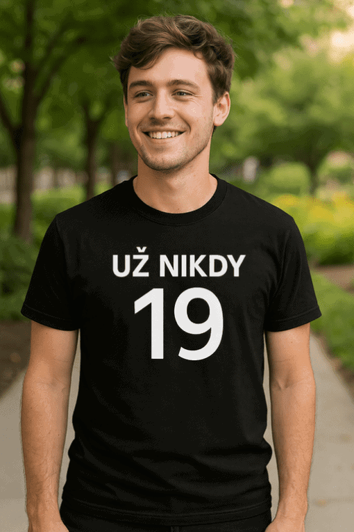 Pohled na mladého muže v černém tričku s nápisem "UŽ NIKDY 19" na procházce v přírodě.
