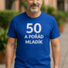 Muž v modrém tričku s nápisem "50 a pořád mládík" na ulici.