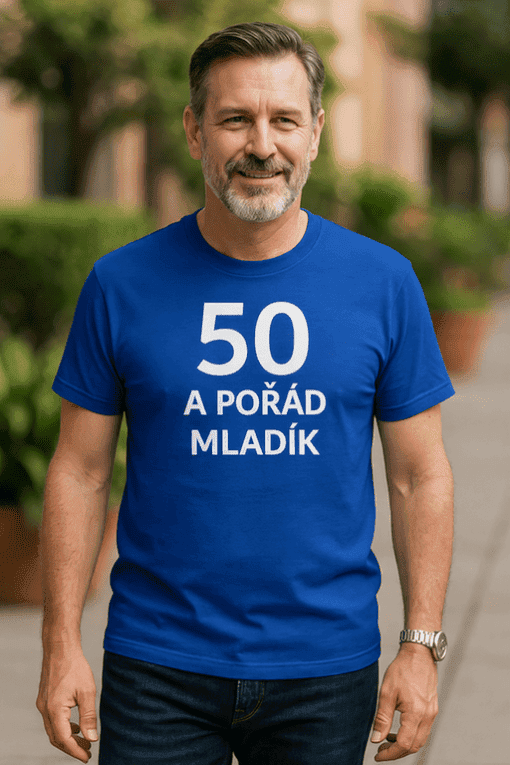 Muž v modrém tričku s nápisem "50 a pořád mládík" na ulici.