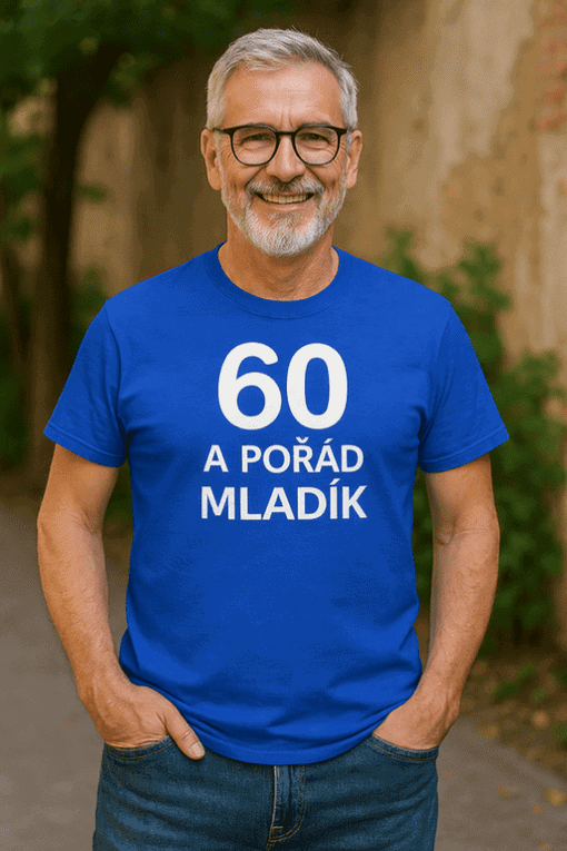 Přátelský starší muž s úsměvem na obličeji v modrém tričku s nápisem "60 a pořád mladík".