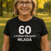 Žena v tričku s nápisem "60 a pořád štíhlavá mladá", módní a inspirativní vizuál.