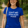 Žena v modrém tričku s nápisem "Chyť mě! Zítra bude pozdě" na venkovním prostředí, ideální pro outdoorové aktivity.