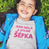 Dětské tričko s nápisem "Jsem malá a stejně šéfka" na zelené louce.