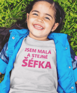 Dětské tričko s nápisem "Jsem malá a stejně šéfka" na zelené louce.