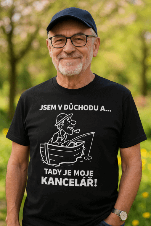 Starší muž v tričku s nápisem a žraločím obrázkem, venku v přírodě.