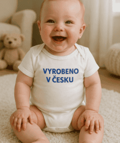 Dítě s nápisem "Vyrobeno v Česku" na tričku, doma, s plyšovým medvědem v pozadí.