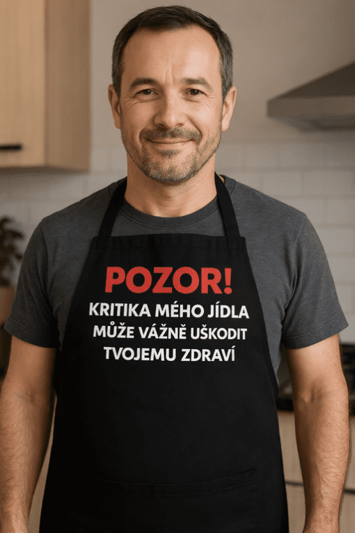 Muž v kuchyni s varnou zástěrou.