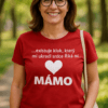 Šťastná žena v červeném tričku s nápisem "MÁMO" v parku.
