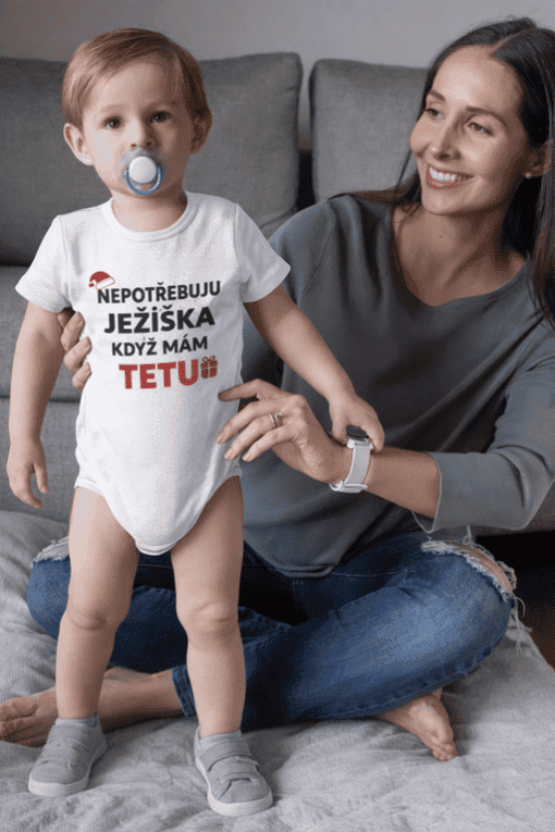 Dítě s tričkem o Ježíškovi a matka na gauči.