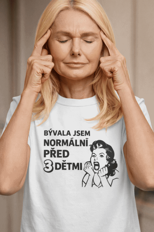 Žena s nápisem „Bývala jsem normální před 3 dětmi“, symbolizující každodenní stres a rodičovskou únavu.