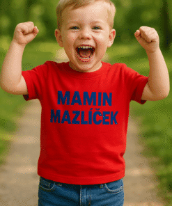 Dítě s úsměvem a vítěznou pózou na volné přírodě, tričko s textem MAMIN MAZLÍČEK.